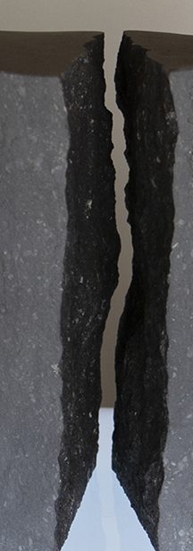 Grauer Stein Zwei geschliffene, fast schwarze Steine mit gegenüberliegenden Bruchkanten