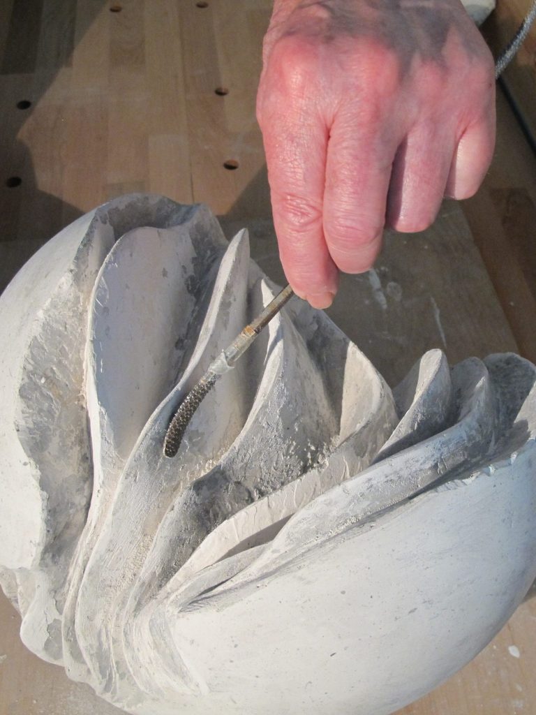 Handwerk Nahaufnahme einer Hand mit Werkzeug, die eine Skulptur bearbeitet