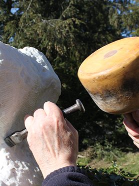 Handwerk Nahaufnahme einer Hand mit Meißel und einem Steinmetz-Hammer, die einen Frauenkopf aus Marmor bearbeitet
