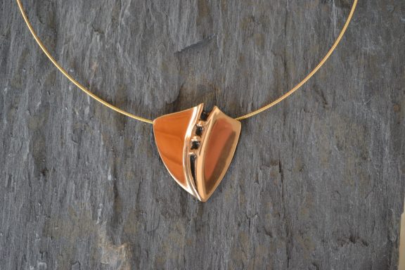 Gold-Anhänger Ein Anhänger in Trpezform und perlenförmigen Kernen mit Halskette, beide goldglänzend